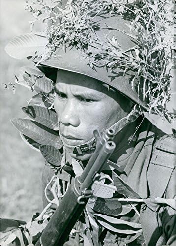Гроздобер фотографија на виетнамски војник во маскирна и држејќи го пиштолот. Виетнам.